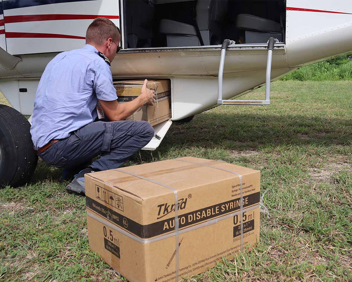 An MAF pilot unloading medical supplies from the aircraft for the people on Atauro Island