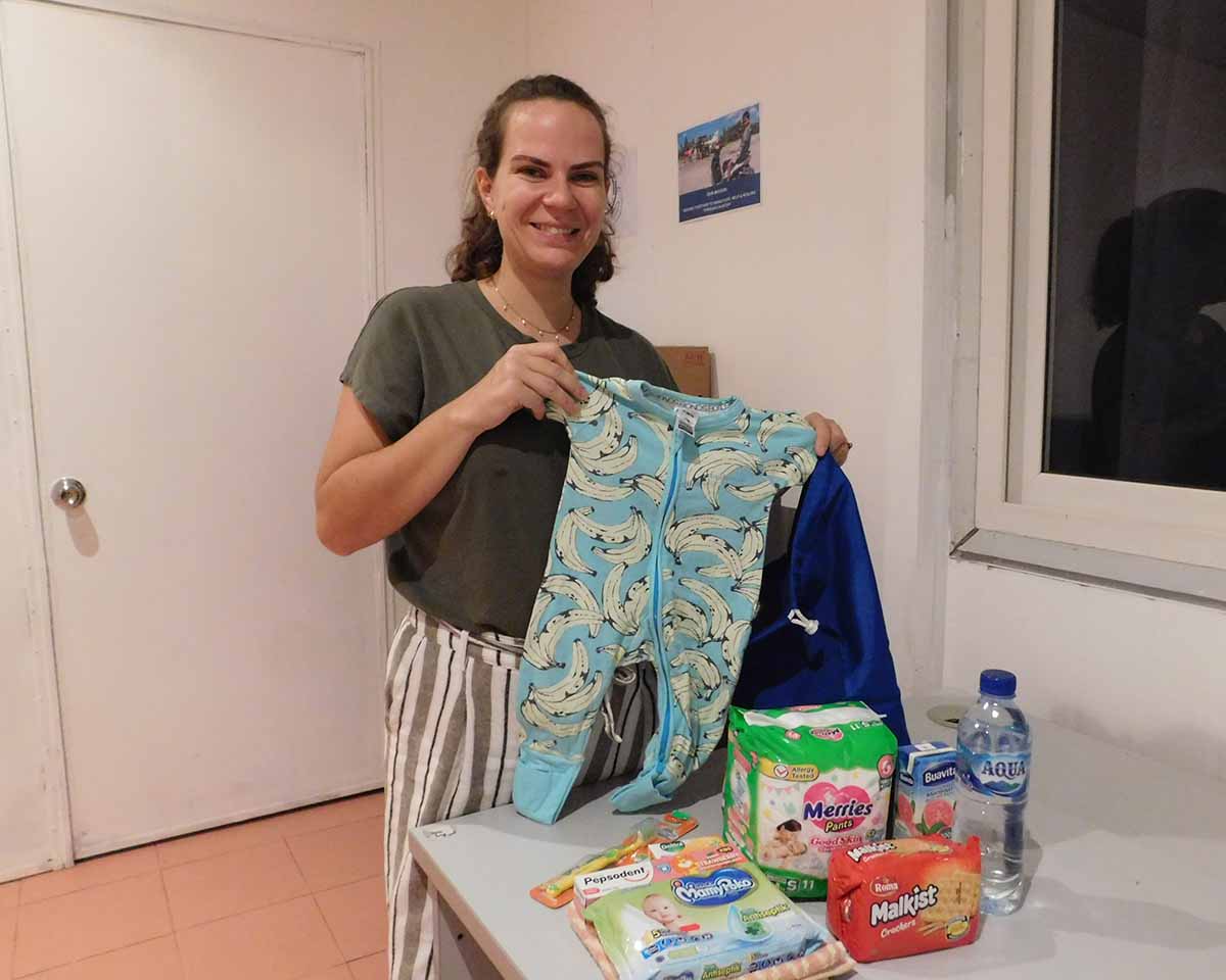 Rebecca Klassen, the co-ordinator of carepack projects in Timor-Leste, holding up some baby clothes